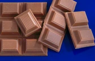 Broken Bar Of Chocolate On Blue Background Closeup Elevated Stock