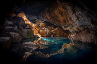 Iceland Cave Surrouned With Blue Body Of Water 5k Wallpaper HD Nature