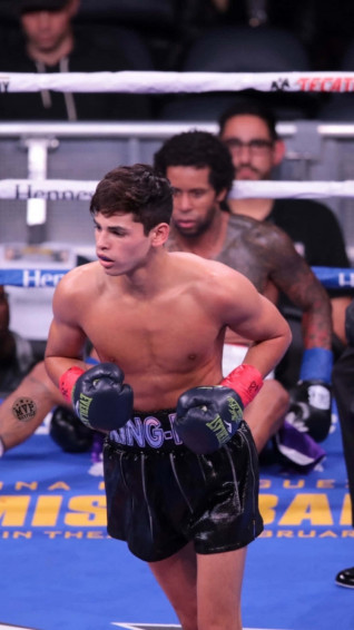 A Boxer Is Standing On The Ring With His Boxing Gloves