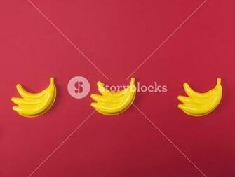 Yellow Plastic Baby Toy Banana On A Red Background Copy Space
