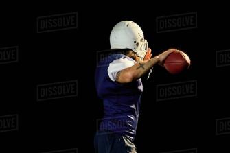 Portrait Of Quarterback With Football Black Background Stock