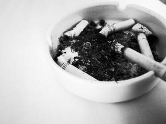 White Ceramic Ashtray And Cigarette Butts Image