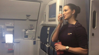 Professional Flight Attendant Inside Aircraft Cabin Wallpaper