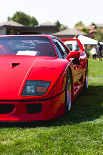 Red Ferrari Italia On Green Grass Field During Daytime Photo