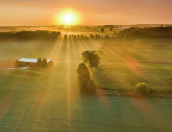 Late Summer Sunrise Over Misty Rural Landscape With Long Shadows