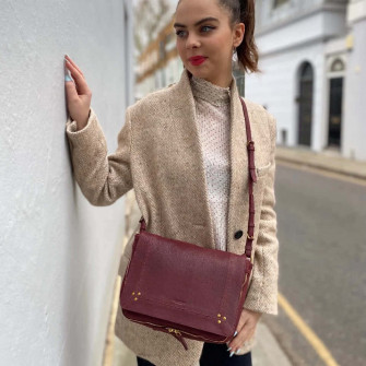 Chic Woman Flaunting Her J R Me Dreyfuss Igor Bag On The Wallpaper