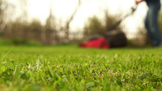 Man Mowing Grass In The Blurred Background Stock Video Footage