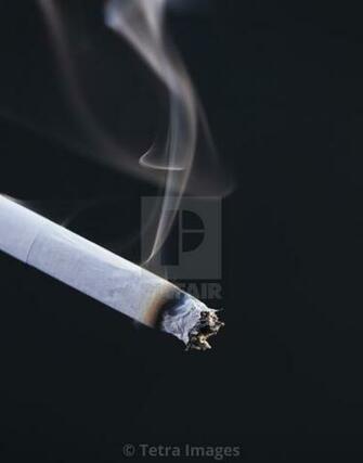 Close Up Of Burning Cigarette On Black Background License