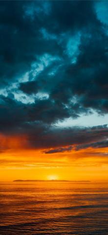 Green And Black Clouds Partly Covering Orange Sky iPhone X