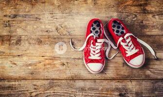Pair Of Red Sneakers On A Floor Studio Shot Wooden