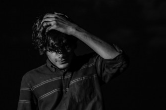 A Black And White Photo Of Man With Curly Hair