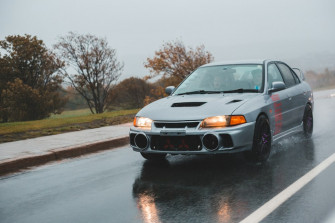 Silver Mitsubishi Sedan Travelling In The Wet Road Photo