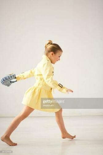 Laughing Little Girl Running Barefoot In Front Of Light Background