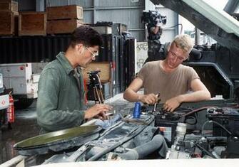 Two Seabees Perform Preventive Maintenance On A Truck While Navy