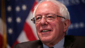 Bernie Sanders Smilingwith American Flag Wallpaper