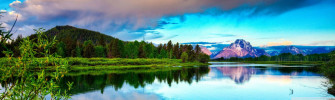 A Lake With Mountains And Clouds In The Background