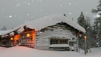Warm Welcoming Snow Covered Timber Or Log Home In A Winter Snowfall