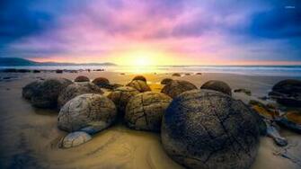 Rounded Rocks On Sandy Beach Wallpaper