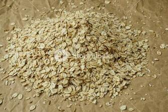 Pouring Oatmeal Flakes On Crumpled Paper Background Royalty