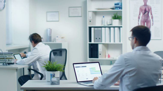 Male Doctor Reads Patient S Medical Card On His Laptop And Makes