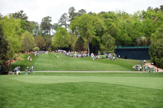 A Group Of People Walking Down Green Golf Course Wallpaper