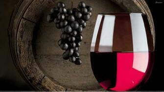 Red Wine Glass N Hanging Black Grapes Closeup Wallpaper