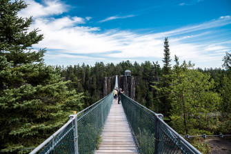 Group Of People On A Hanging Bridge Wallpaper