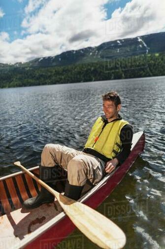 Man In Canoe On Byers Lake With Forested Foothills The