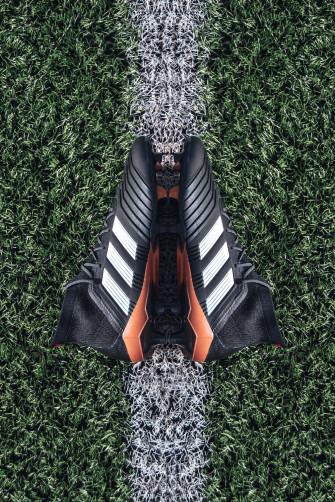 Pair Of Black Adidas Cleats On Grass Field Photo
