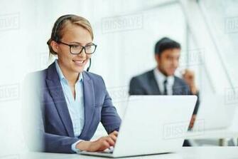 Pretty Operator Consulting Clients Online With Colleague On