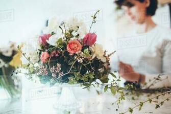 Close Up Of Flower Arrangement With Florist In Background At Store