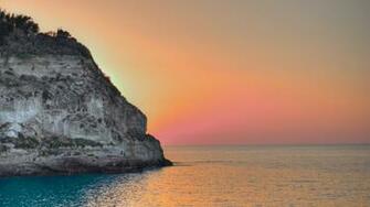 Ocean Sun Setting Behind Cliff 4k Ultra HD Desktop Wallpaper