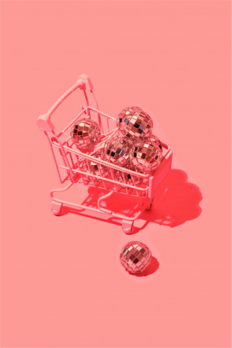 A Shopping Cart With Shiny Balls On Pink Wallpaper