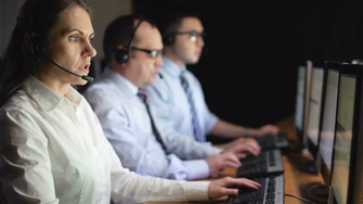 Female Operator Consulting Clients Online With Male Colleagues On