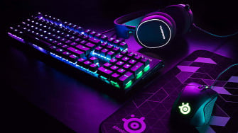 A Computer Keyboard And Mouse With Purple Lights