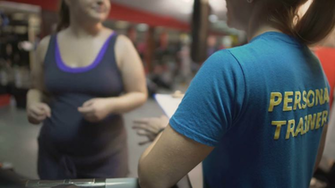 Fat Woman Working Out In Gym With Personal Trainer Exercising On