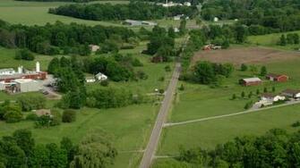 5k Stock Footage Aerial Video Following A Country Road Past Barns