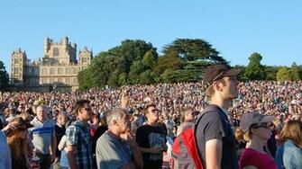 People In The Crowd At Splendour With Wollaton Hall Background