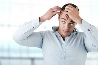 Man Checking Hairline In A Blue Background Vegas Valley Hair