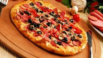 Pepperoni Pizza On Top Of Wooden Board Beside Stainless Steel