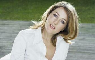 Gillian Anderson With Her Head Leaning On A Side Wallpaper
