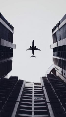 Airplane Flying Above The Buildings 5k In Resolution