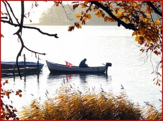 Autumn Time And A Fishermantending His Boat