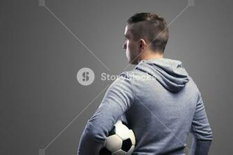 Young Sportsman Holding A Soccer Ball Studio Shot On Gray