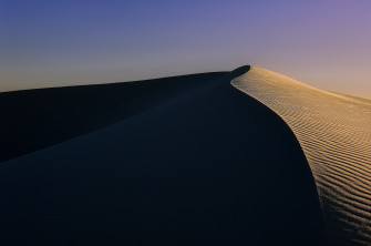 The Sun Is Setting On Top Of A Sand Dune In Middle Desert Wallpaper
