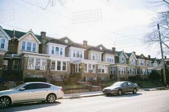 Cars Parked On Street Along Row Of Residential Houses In