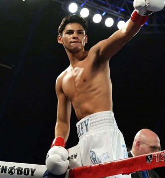 A Boxer Is Standing On The Ring With His Hands Raised