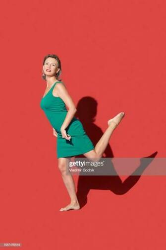 Portrait Confident Barefoot Woman On Red Background High Res Stock