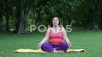 Beautiful Fat Woman Doing Yoga On The Mat In Park Clip