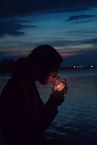 A Woman Holding Lit Candle In Front Of Body Water Photo